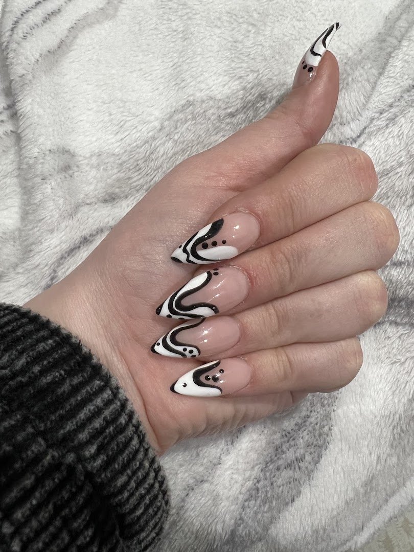 Manicured hands with glossy pink nails on a salon chair.