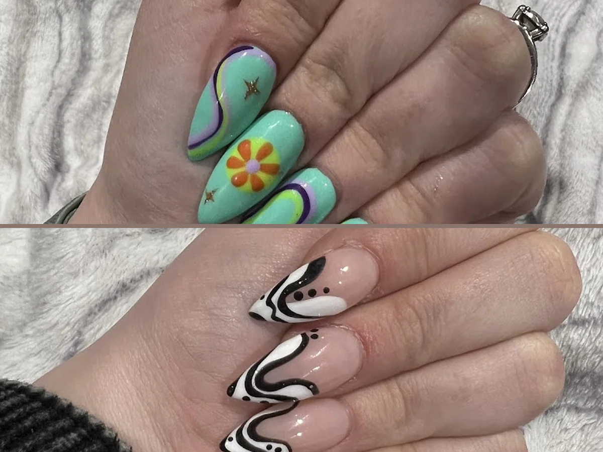 Nail technician shaping acrylic nails beside polish bottles.
